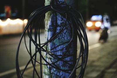 Close-up of cables hanging on pole at night