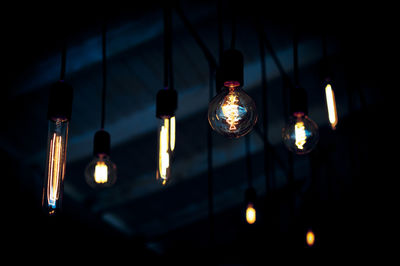 Various glass light bulbs glowing in darkness.