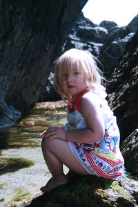 Full length of cute girl sitting outdoors