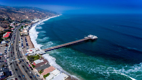 Aerial view of road beside sea