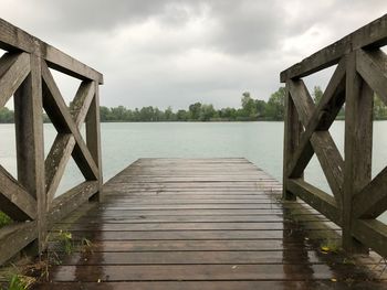 Wooden pier on water against sky