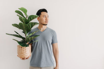 Young man looking away against white background