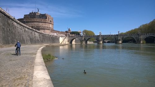 Arch bridge over river against sky