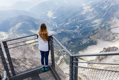 Young girl enjoys the views of the alps from the observation deck