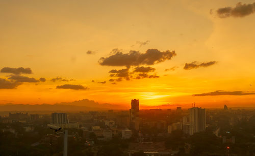 Aerial view of buildings against sky during sunset