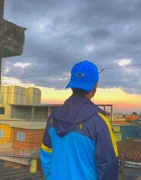 Rear view of man standing against buildings in city