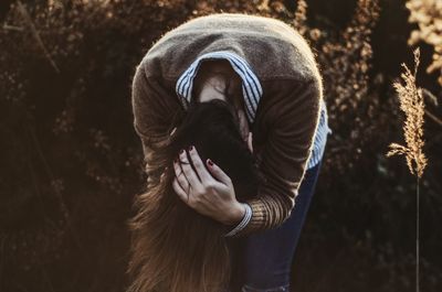 Woman with brown hair bending on land