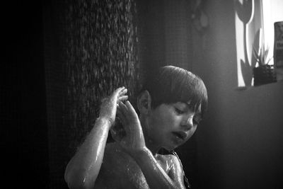 Shirtless boy showering in bathroom