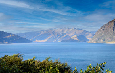 Scenic view of sea and mountains against sky