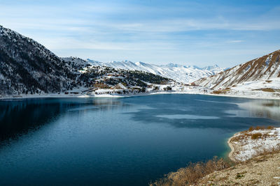 Scenic view of lake and snowcapped mountains against sky