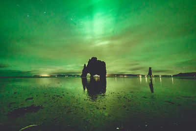 Silhouette man on beach against sky at sunset