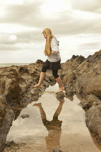 Full length of woman on rock against sky