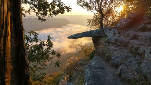 Leopard rock by cloudscape during sunset