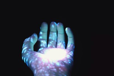 Close-up of human hand against black background