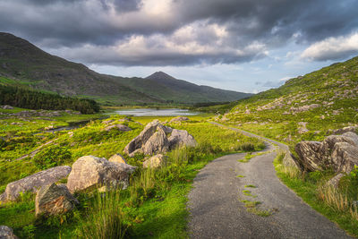 Beautiful landscape with winding country road illuminated by sunlight at sunset black valley ireland