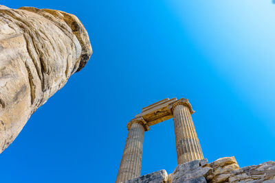 Low angle view of rock formation against clear blue sky