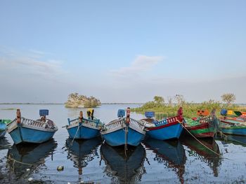 Boats moored in lake against sky