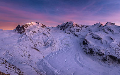 Scenic view of snowcapped mountains and glacier against sky during sunset