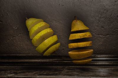 Close-up of yellow fruit on table against wall