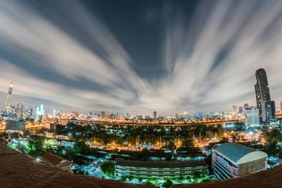 High angle view of illuminated city buildings against sky at night