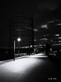 Illuminated road against sky at night during winter