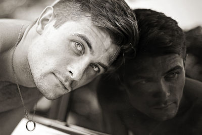 Portrait of handsome young man leaning on mirror in bathroom