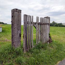 Wooden fence on field against sky