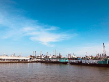 Commercial dock by sea against blue sky