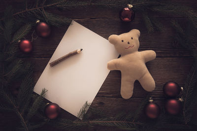 Close-up of christmas decorations with blank paper on pencil on table