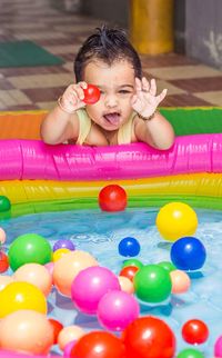 Portrait of smiling girl with multi colored balloons