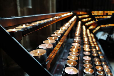 Lit tea light candles on shelves in church