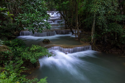 Hua mea khamin waterfall have tropical trees, ferns, growth up on waterfall in the morning light, 