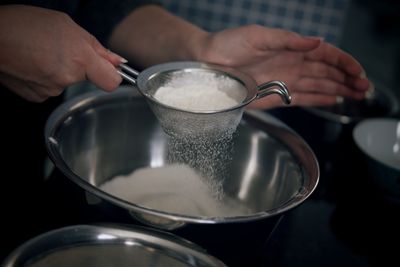 Cropped hand straining flour