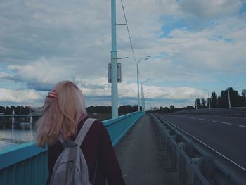 Woman standing on road against sky