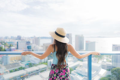 Rear view of woman standing against cityscape