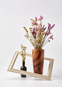 Close-up of vase on table against white background