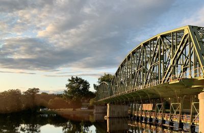 Bridge over river against sky during sunset