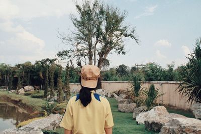 Woman standing by plants against sky