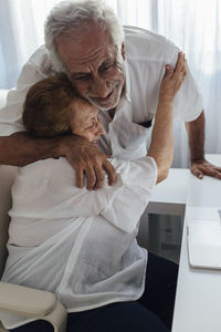 Happy senior man embracing mother at home