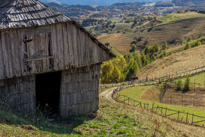 Abandoned barn on field by mountain