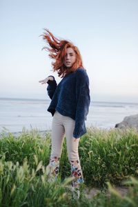 Woman standing by sea against sky