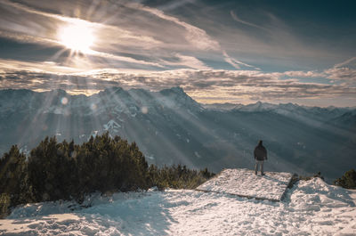 Man standing at observation point against snowcapped mountains