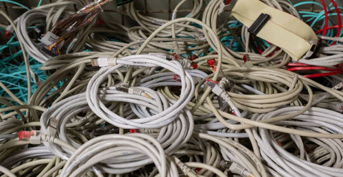 Old it network cables and power cables stored in a lattice box for disposal