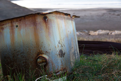 Close-up of old rusty machine on field