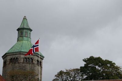 Low angle view of flag on building against sky