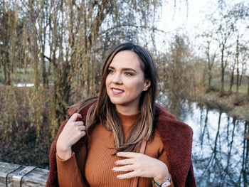 Portrait of happy young woman in winter clothes in park.