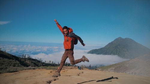 Full length of man paragliding against sky