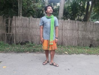 Full length of young man standing against plants