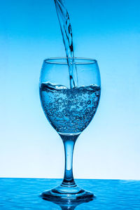 Close-up of drink in glass against blue background