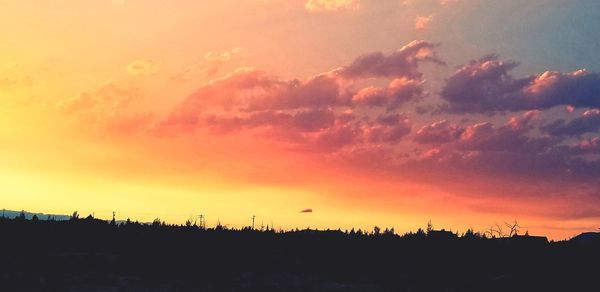 Silhouette landscape against dramatic sky during sunset